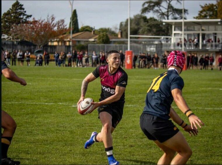Carson Hunter running with the ball during a rugby match